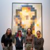 Two students stand with professor and curator in front of a large painting