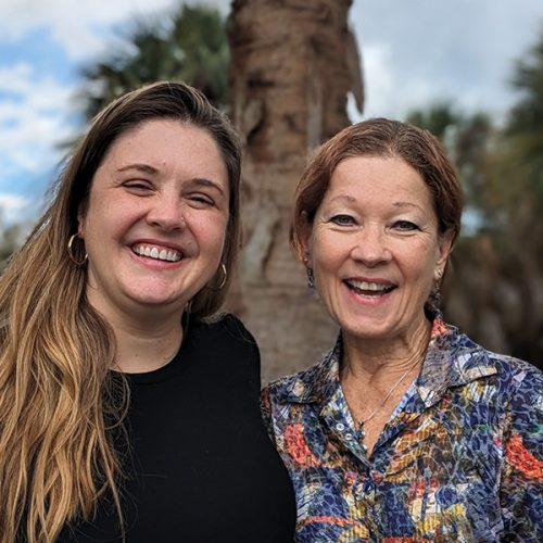 Professor and former student stand side to side in front of Florida landscape