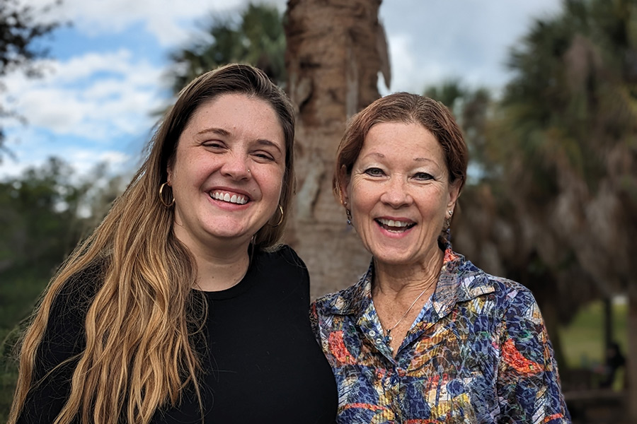 Professor and former student stand side to side in front of Florida landscape