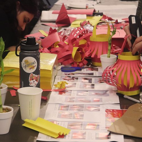 Table full of construction paper and bamboo pots