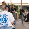 Student with shirt that reads "We can do MOR with less" stands at a group event