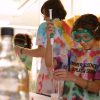Middle schooler in tie-dye uses beaker in a lab