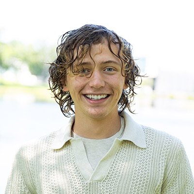 Student smiles at camera while standing outdoors