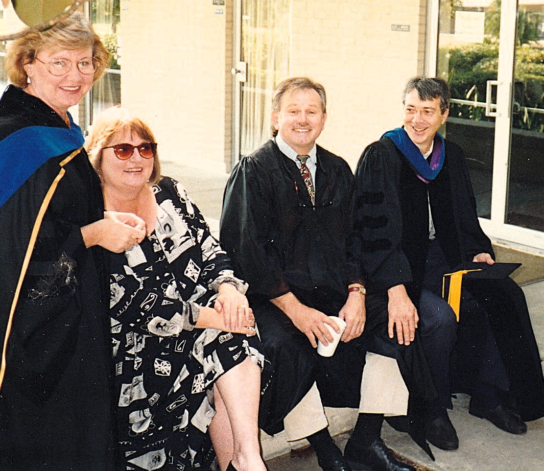 Group of people in graduation attire seated outside