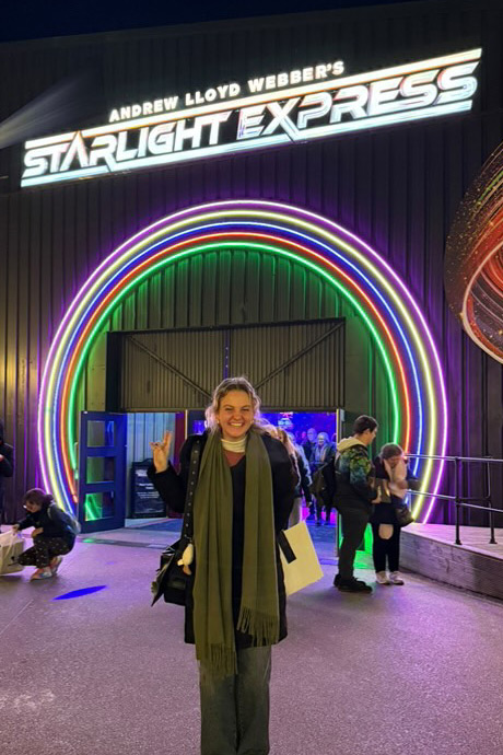 Student stands under sign that reads Andrew Lloyd Weber's Starlight Express