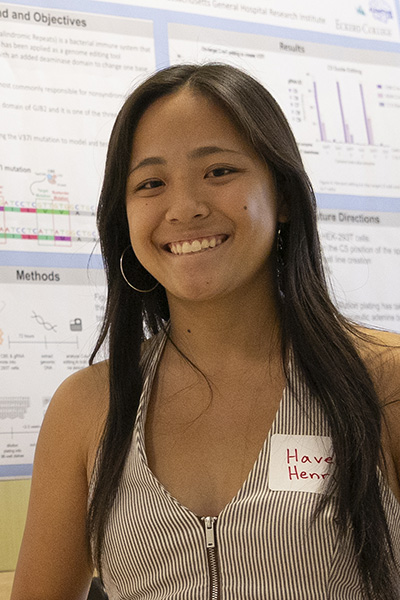 Student standing in front of scientific poster