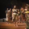 A group of students on stage in prehistoric outfits