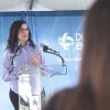 Woman at glass podium in front of sign with words Duke Energy