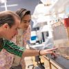 Professor and student lean over to look at bees in a box