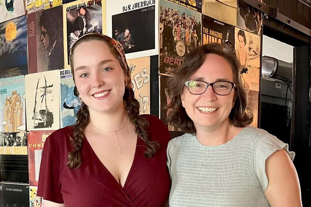 Student and professor stands side by side smiling