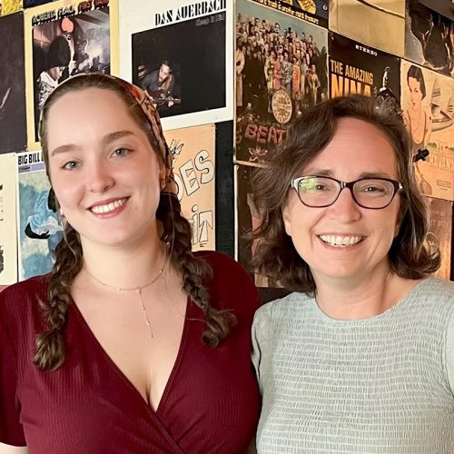 Student and professor stands side by side smiling