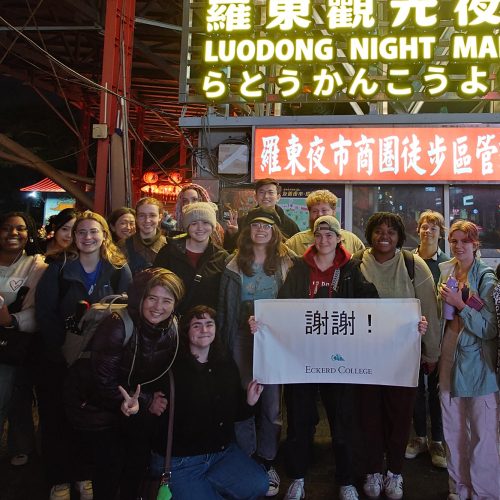 Large group of students stands in front of a sign that reads LUODONG NIGHT MARKET
