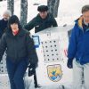 Group of people walk a large white cage through the snow