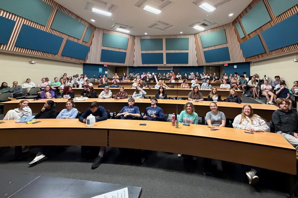 Wide angle view of a lecture hall with four levels of students