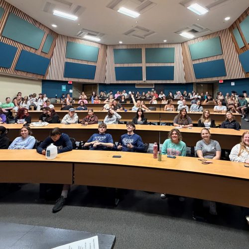 Wide angle view of a lecture hall with four levels of students