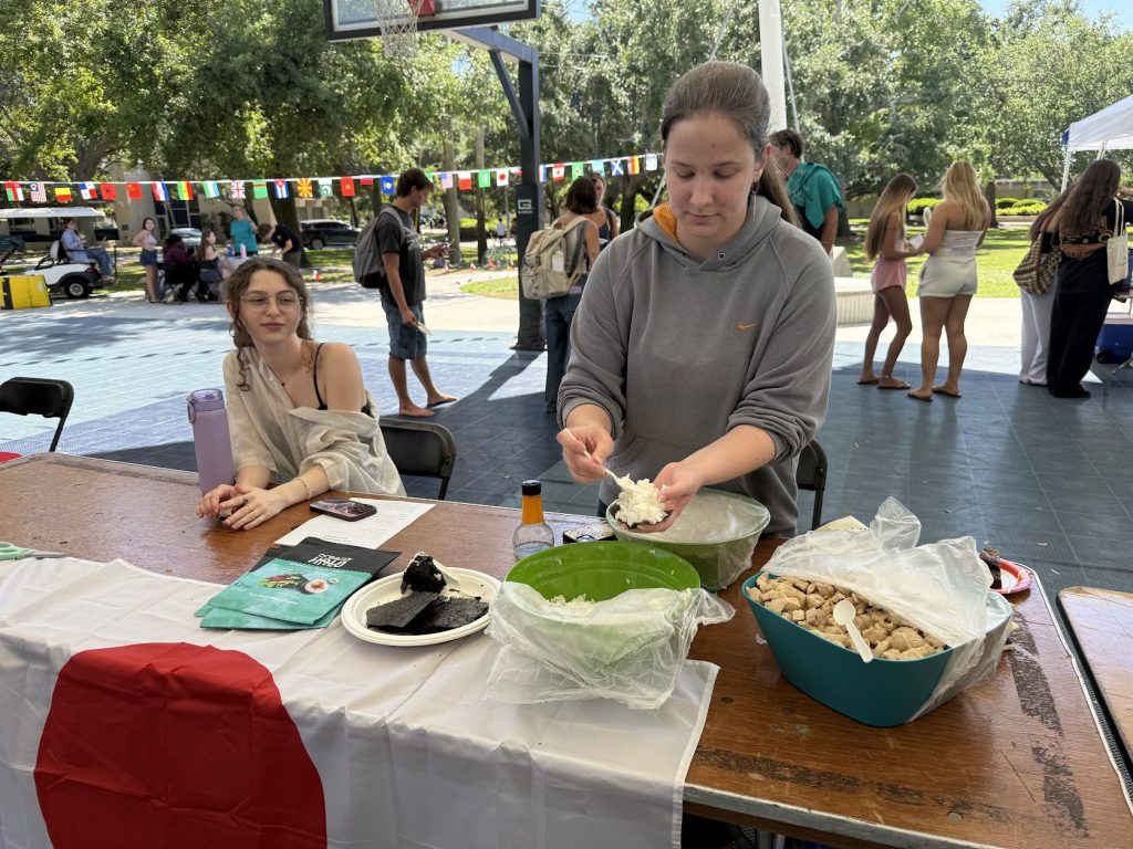 Two girls at a table draped with the flag of Japan. There are two bowls of food on the table.