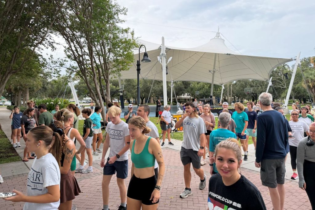 A large group of people walking from right to left.