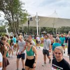 A large group of people walking from right to left.
