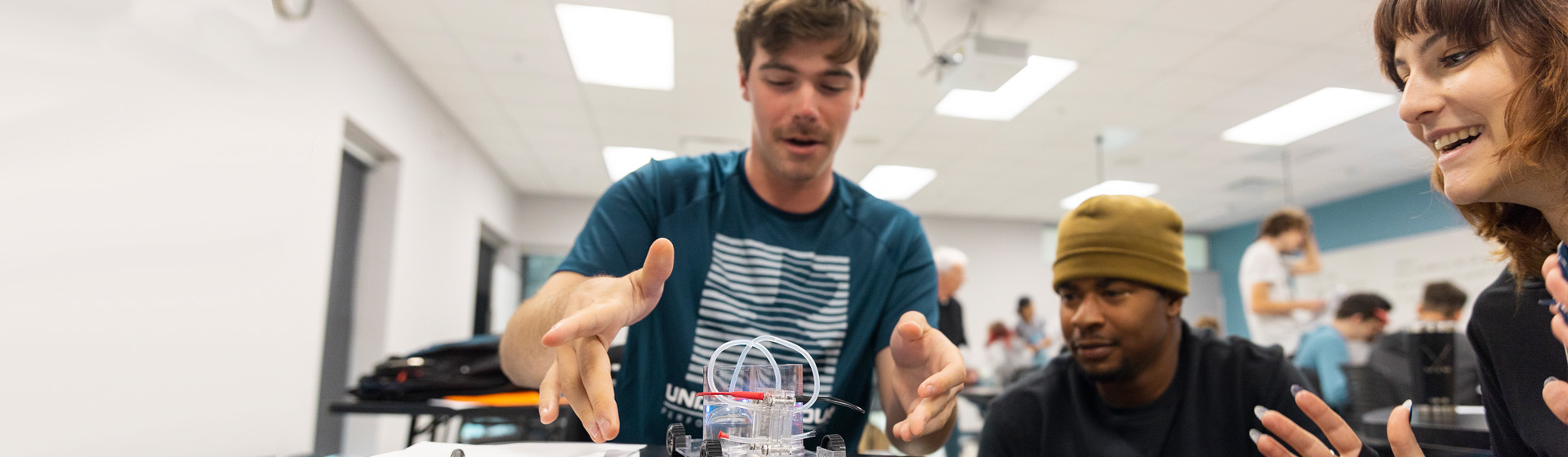 Students in physics lab work with hydrogen car model