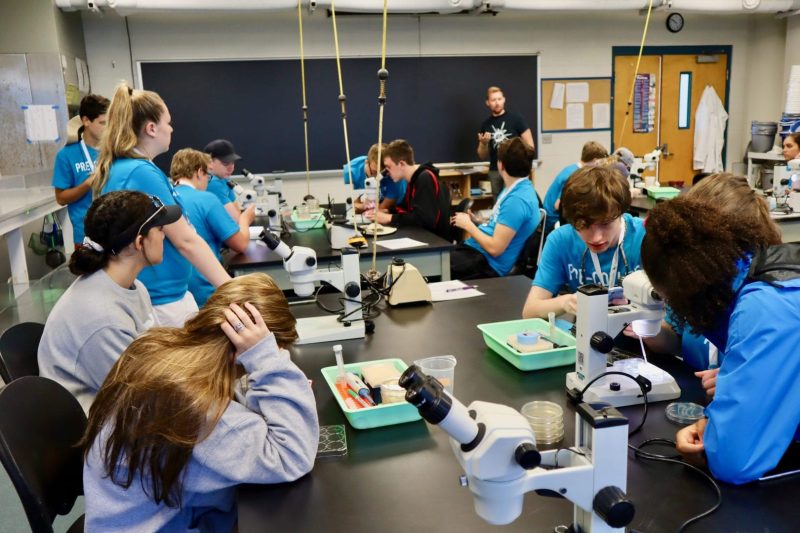 Pre-College students listening to professor in lab