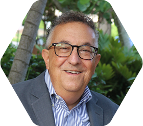 Eckerd College President Jim Annarelli wearing glasses, seated outside