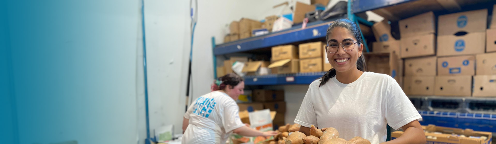 Student holding food on a tray in a pantry