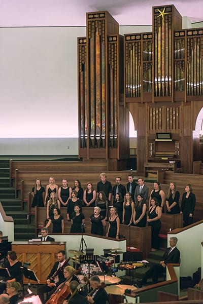 Choir singing in front of large organ