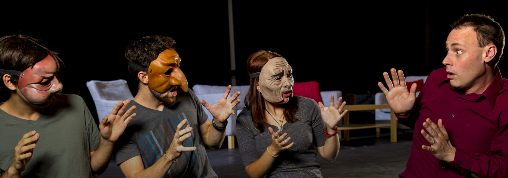Theatre Professor Gavin Hawke talking to students wearing theatre masks