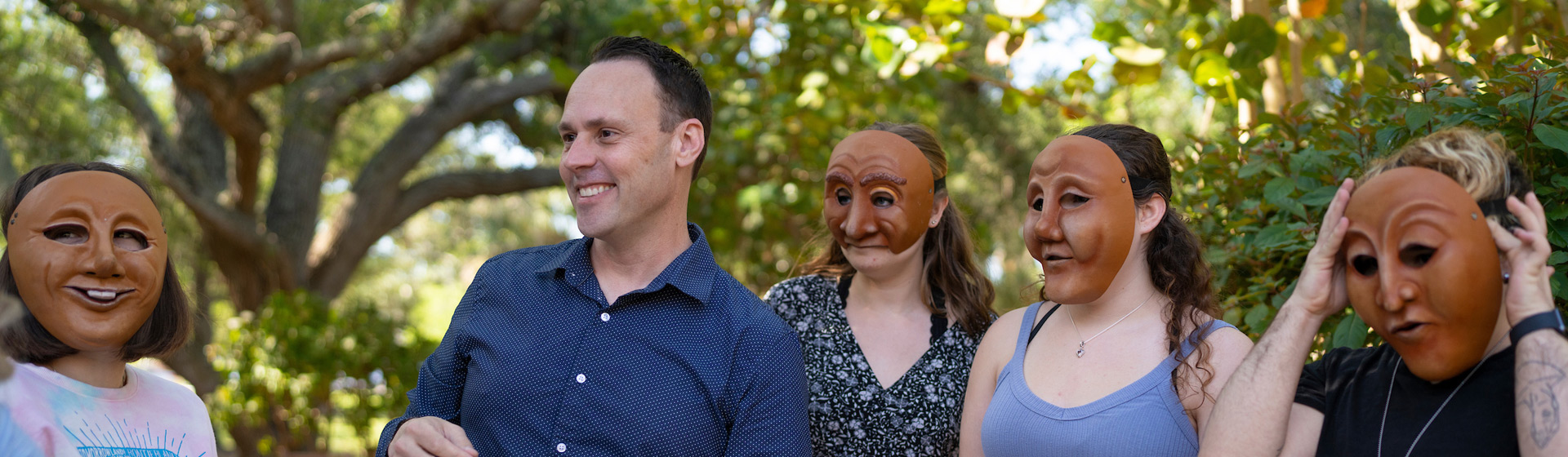Professor stands with four theatre students wearing masks