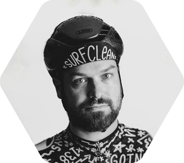 Young man with beard wearing a hat that reads "Surf Clean"