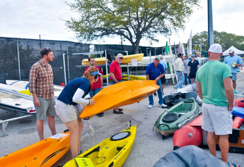 EC-SAR member helping a customer lift a kayak at the Marine Yard Sale