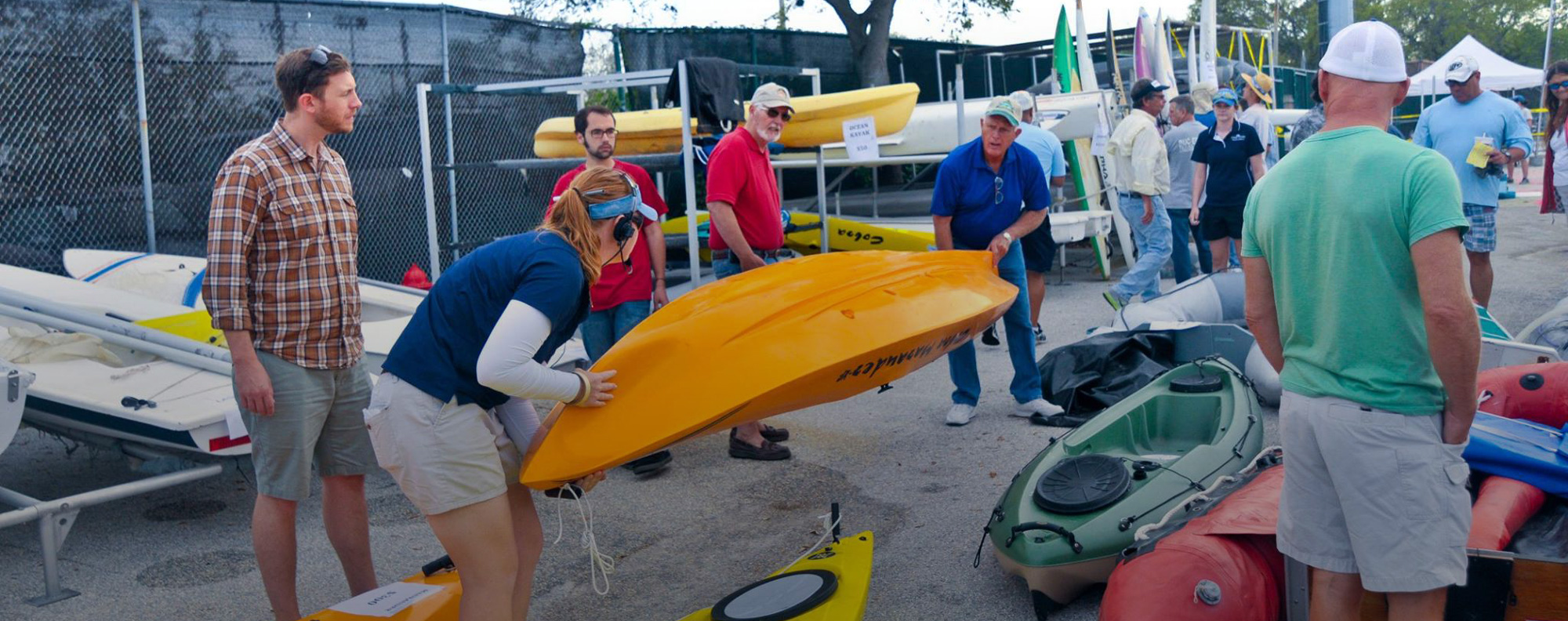 EC-SAR member helping a customer carry a canoe during the Annual Marine Yard Sale