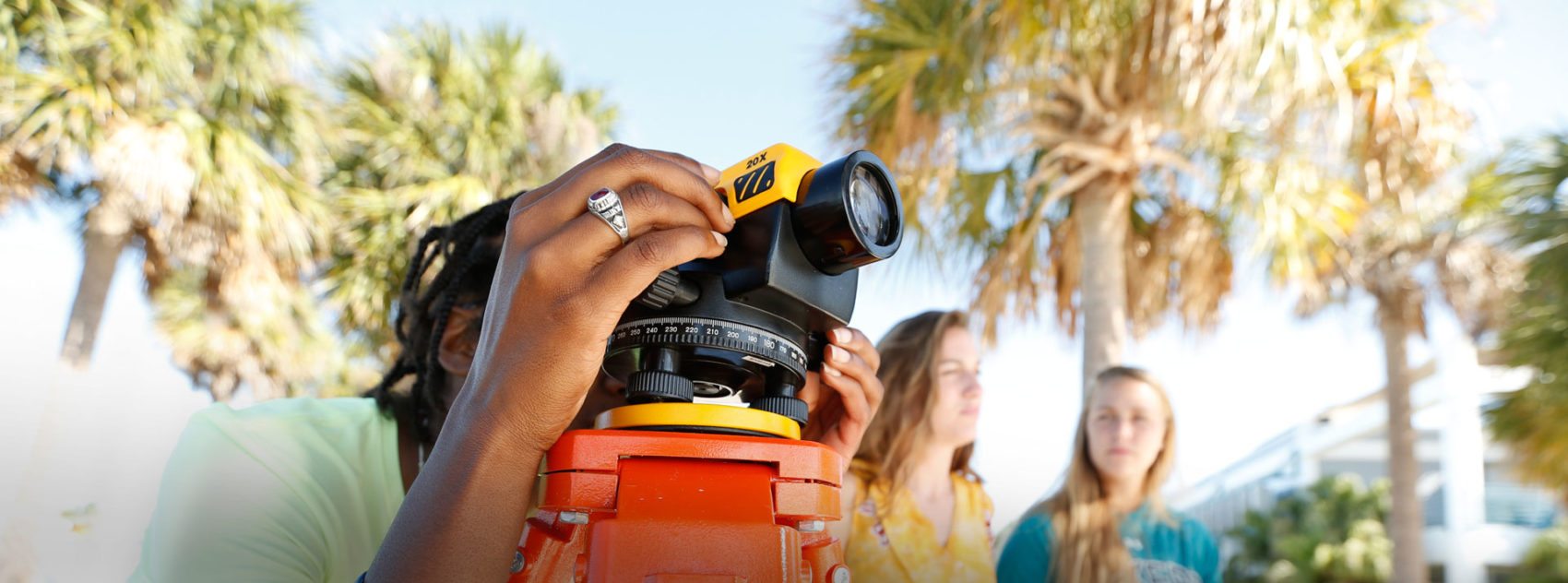 Three female students survey on South Beach with Geoscience and Marine Science Professor Laura Wetzel.
