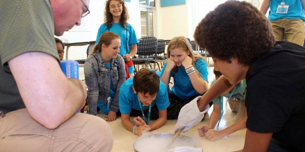 Professor Chris Schnabel helps Summer Science Splash campers make ice cream using liquid nitrogen