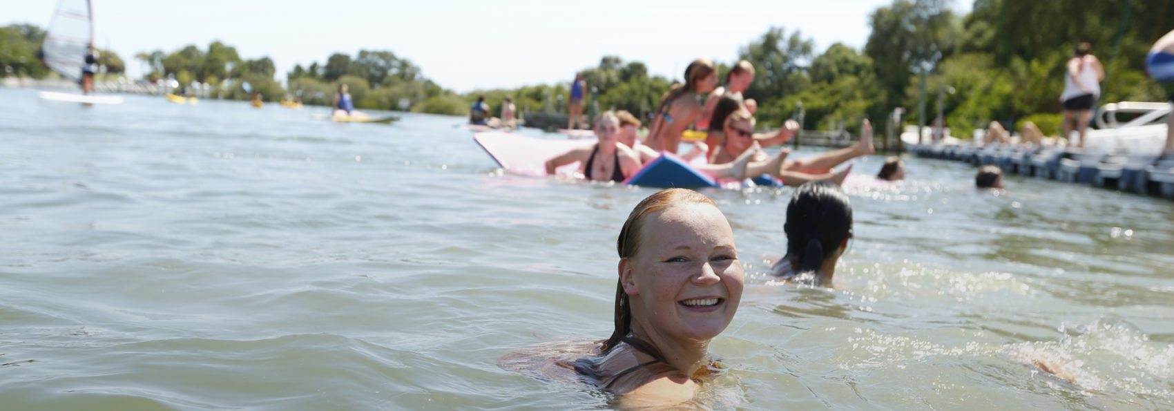 Student smiling in water at Waterfront