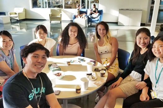 Students seated around a table drinking coffee