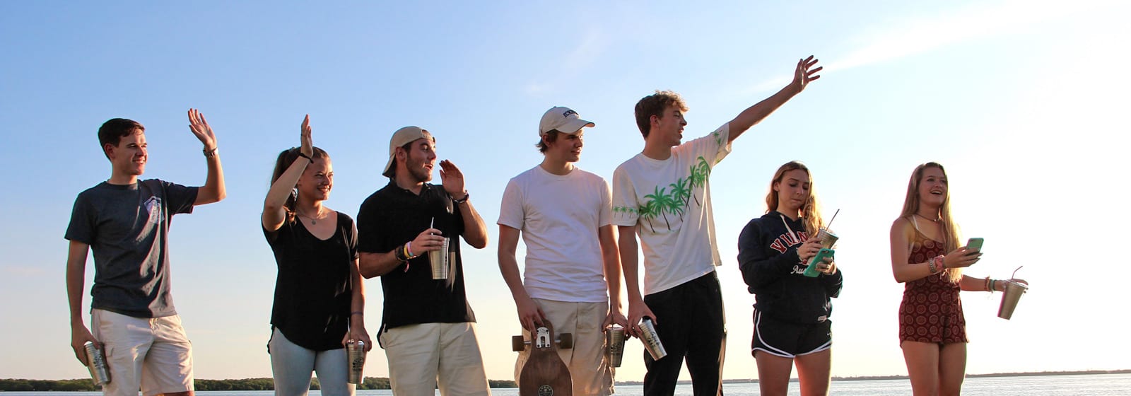 Students on the beach holding reusable containers
