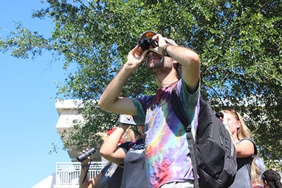 Eckerd birder looking through binoculars