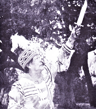 Seminole holding knife in air