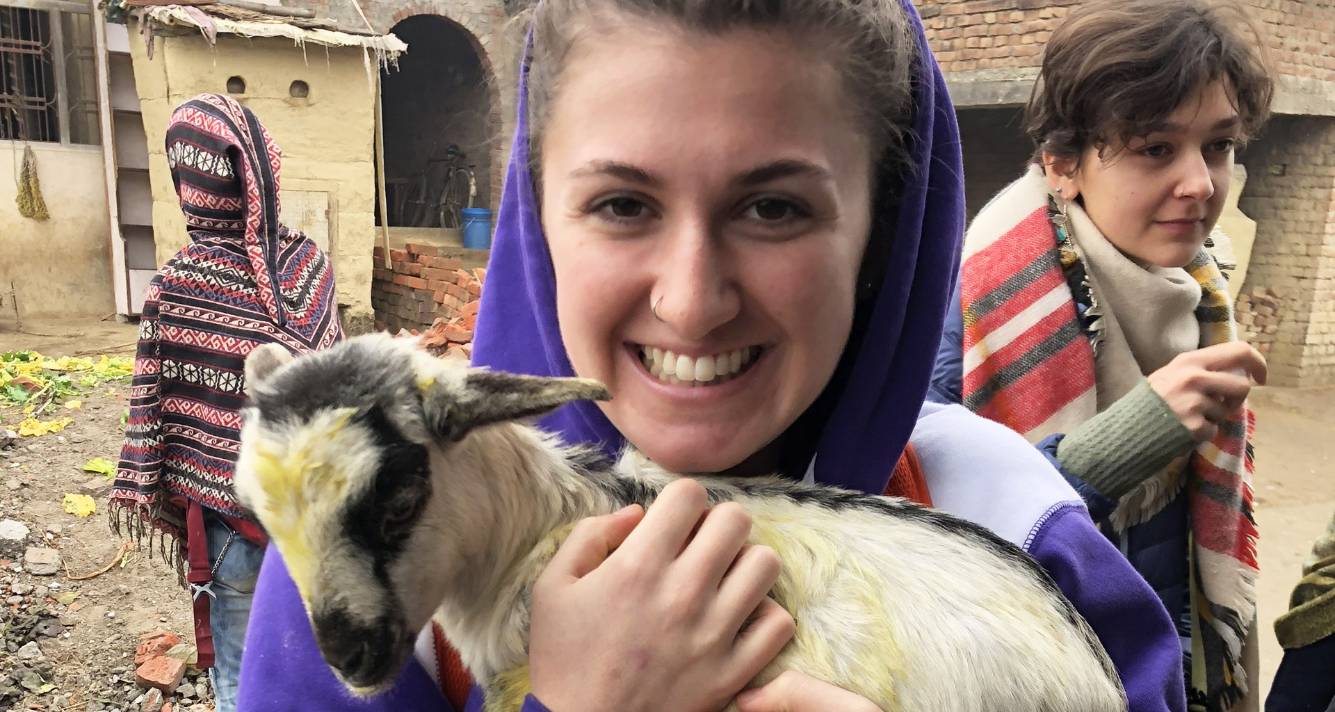 Eckerd student in Nepal holding baby goat