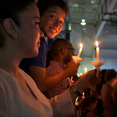 Student holding a candle at ceremony