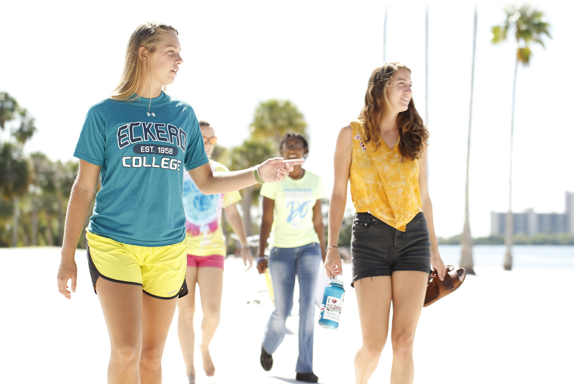 Eckerd College students walking along the beach