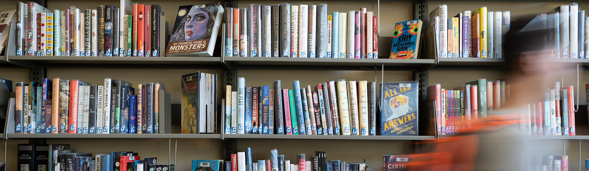Student walking by shelves of books