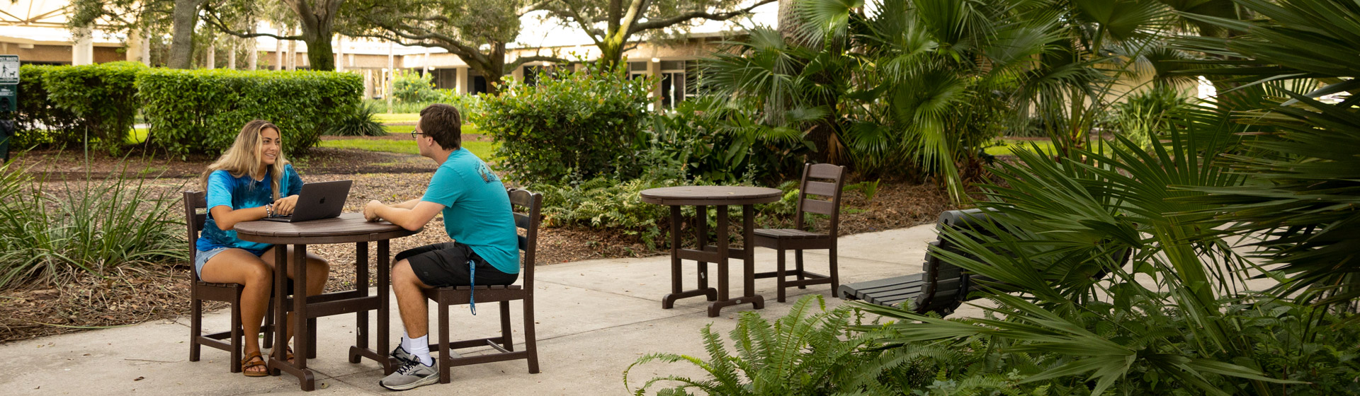 Student and peer mentor seated outside