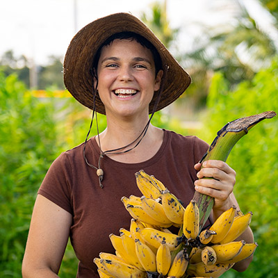 Farmer in big hat, holding bananas