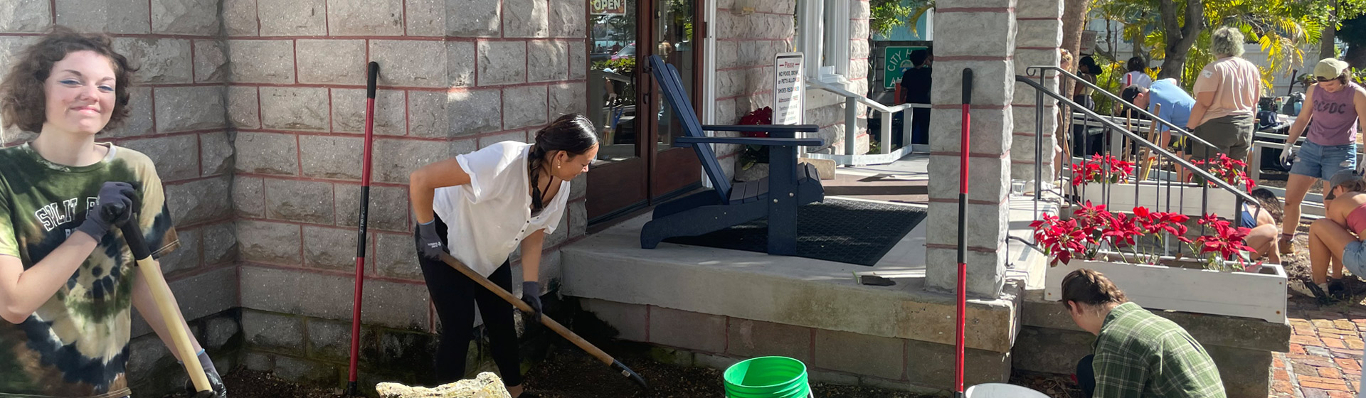 Students work with shovels on a building project