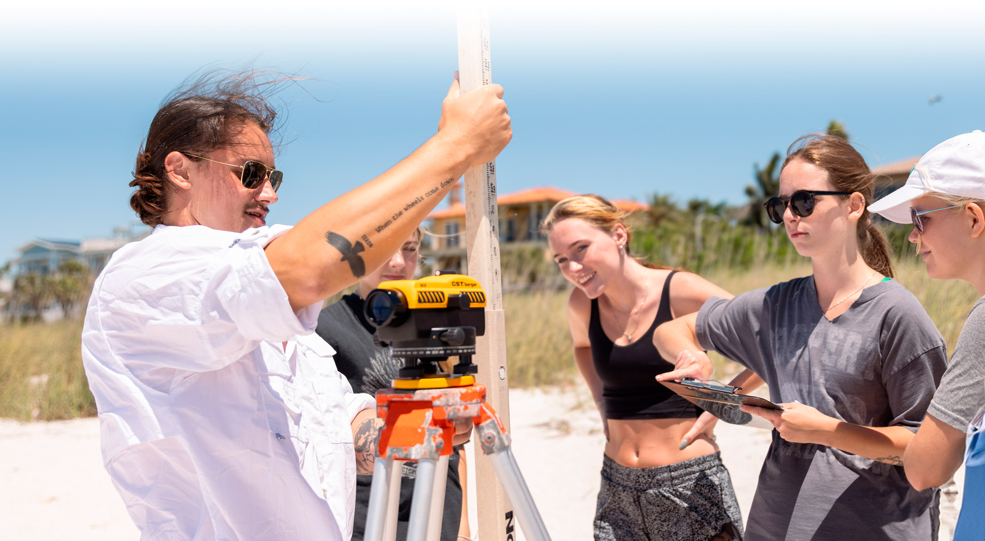 Eckerd College marine science students take geological survey measurements on the beach