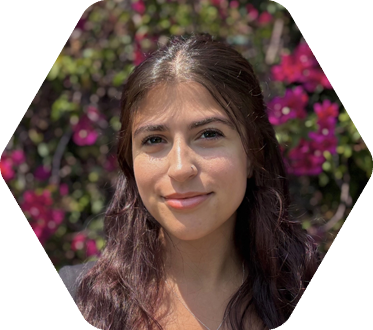 Student standing in front of purple flowers