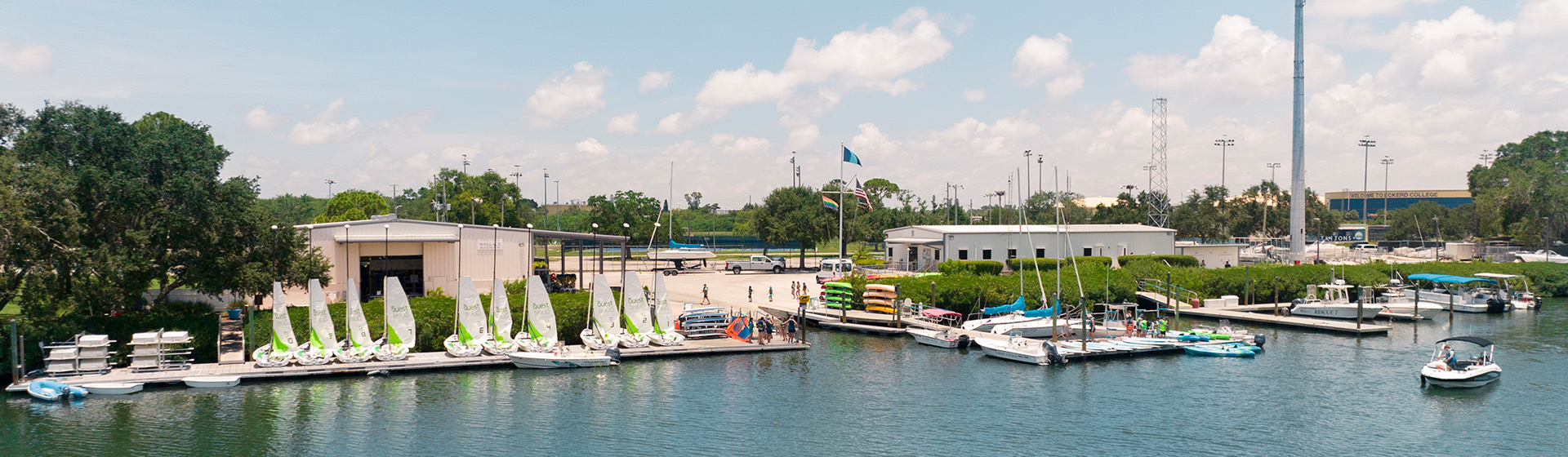 View of boathouse on the water and sailboats and flags flying