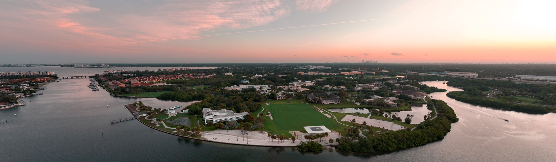Aerial view of college campus along the water's edge at sunrise
